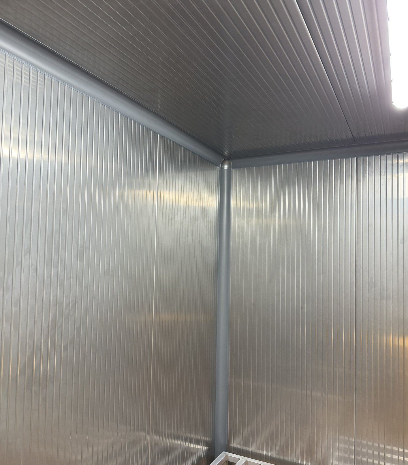 CoRound Basic PVC cove in Stainless Steel Gray 9023 where two walls of stainless steel panels meet the ceiling and each other