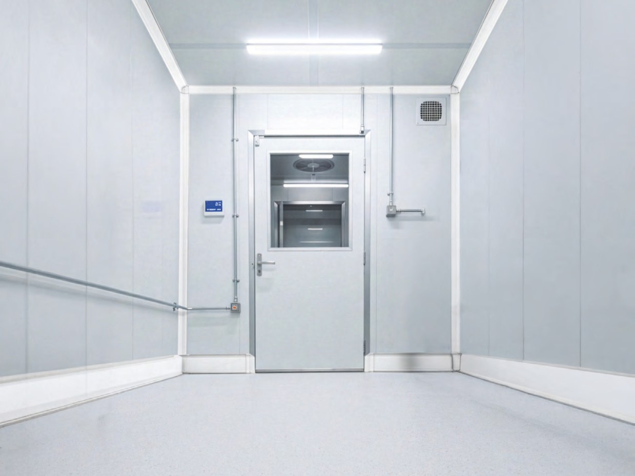 Rendering of a room with a door in its far wall and the CoRound Seal system along the bottom of the walls, up the wall corners and along the ceiling edges